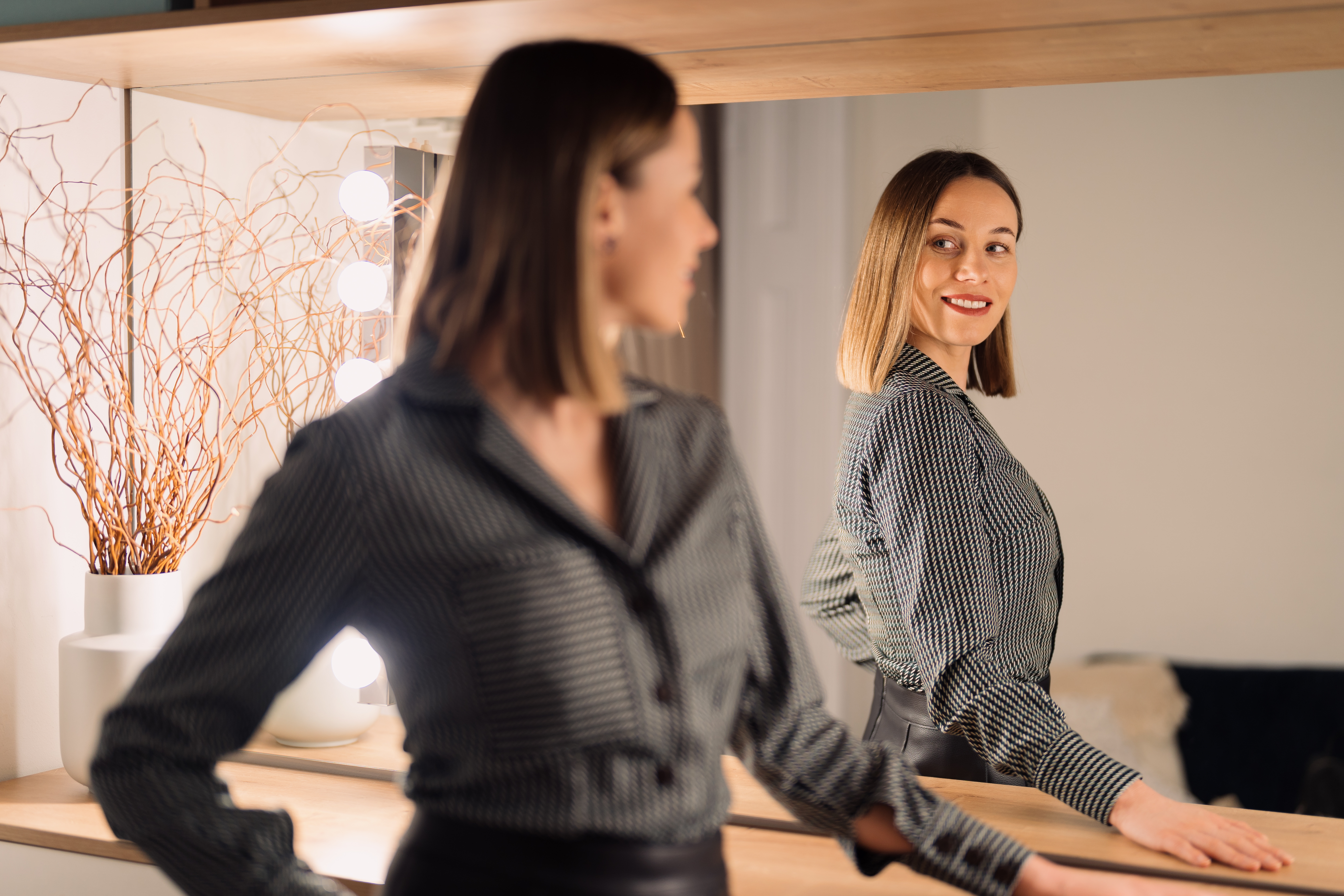 Lovely woman looking at her reflection in the mirror