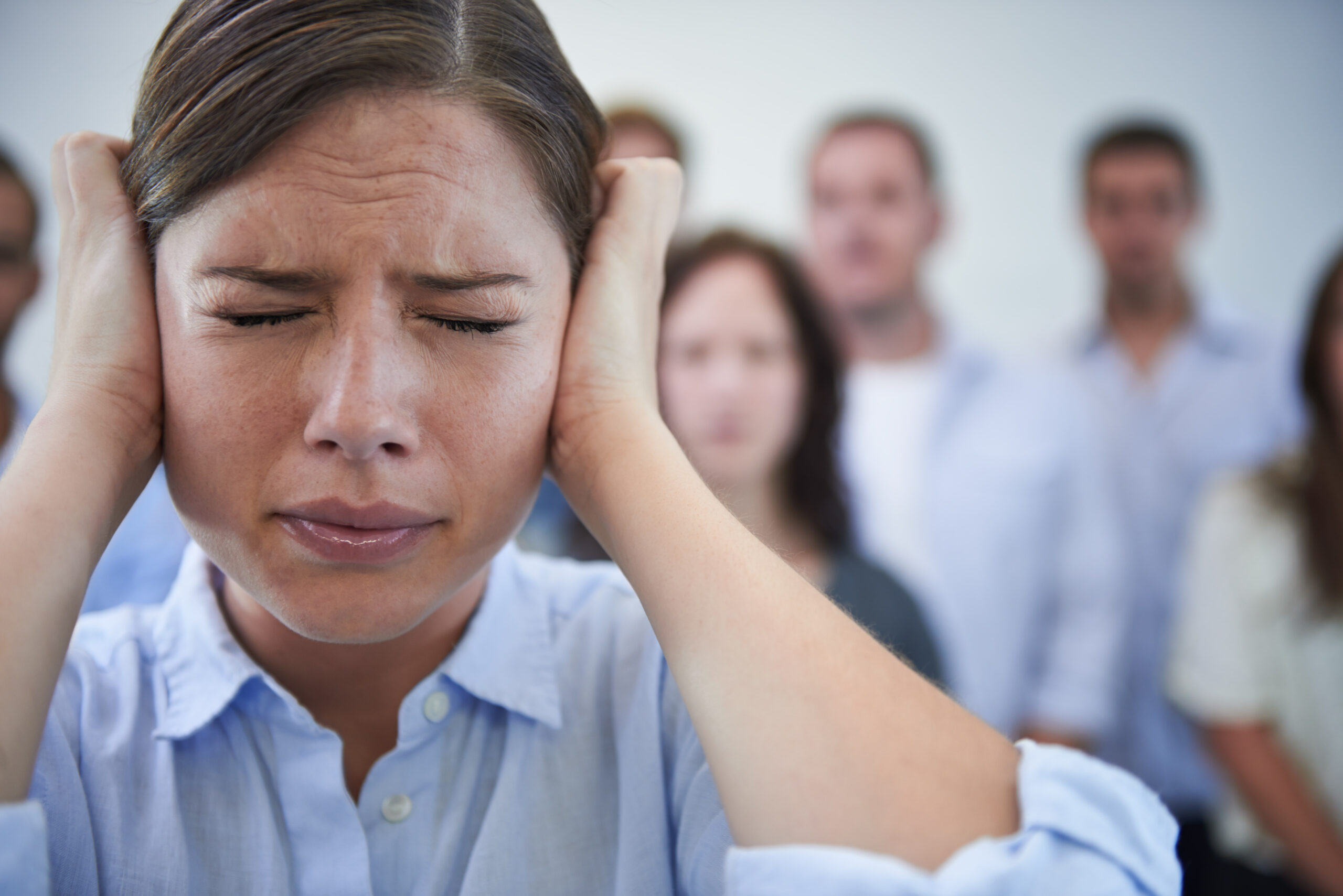 This is too much. Shot of a stressed young woman trying to block out the world